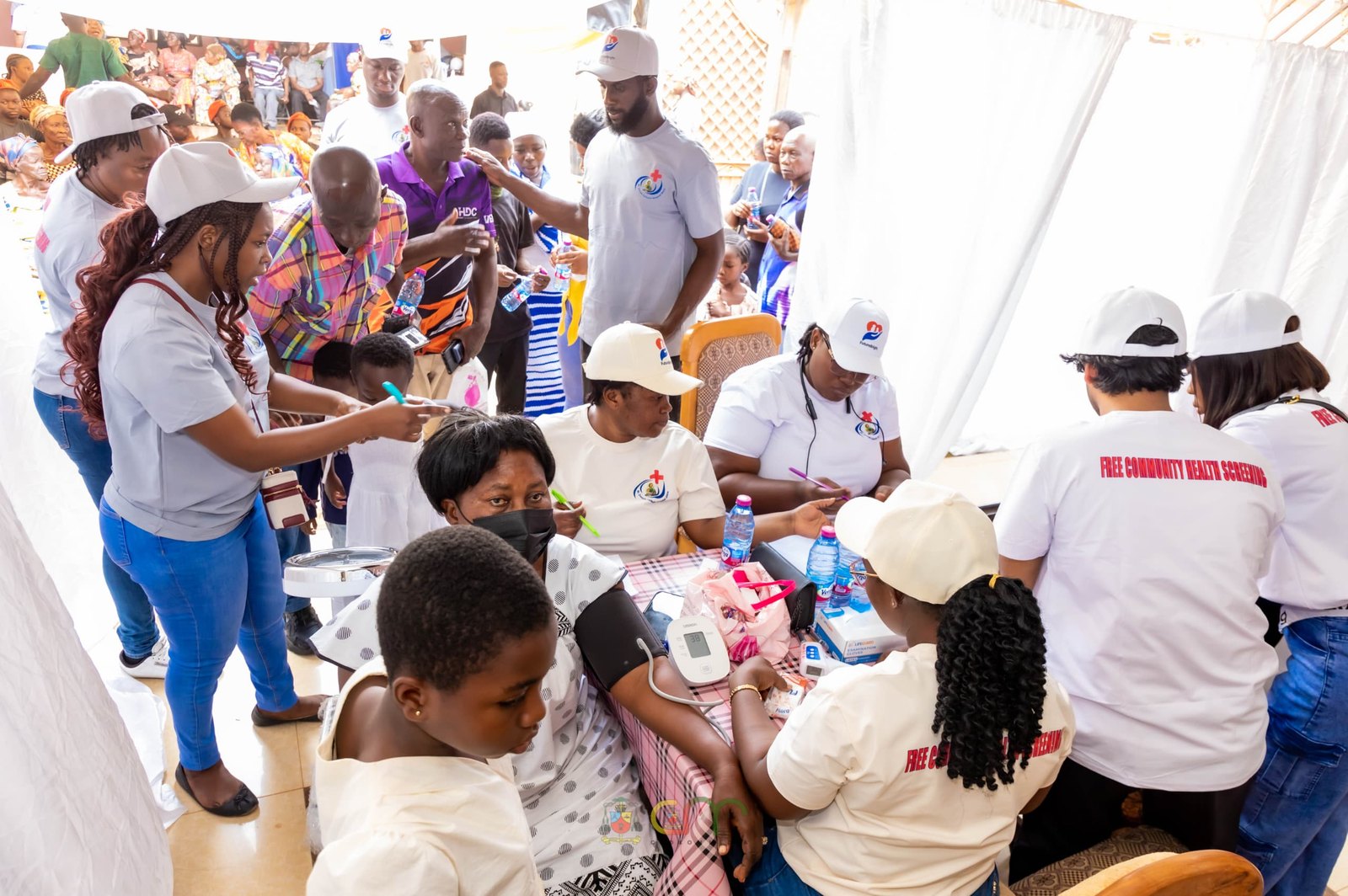 A busy blood-pressure screening station with the community at Abira